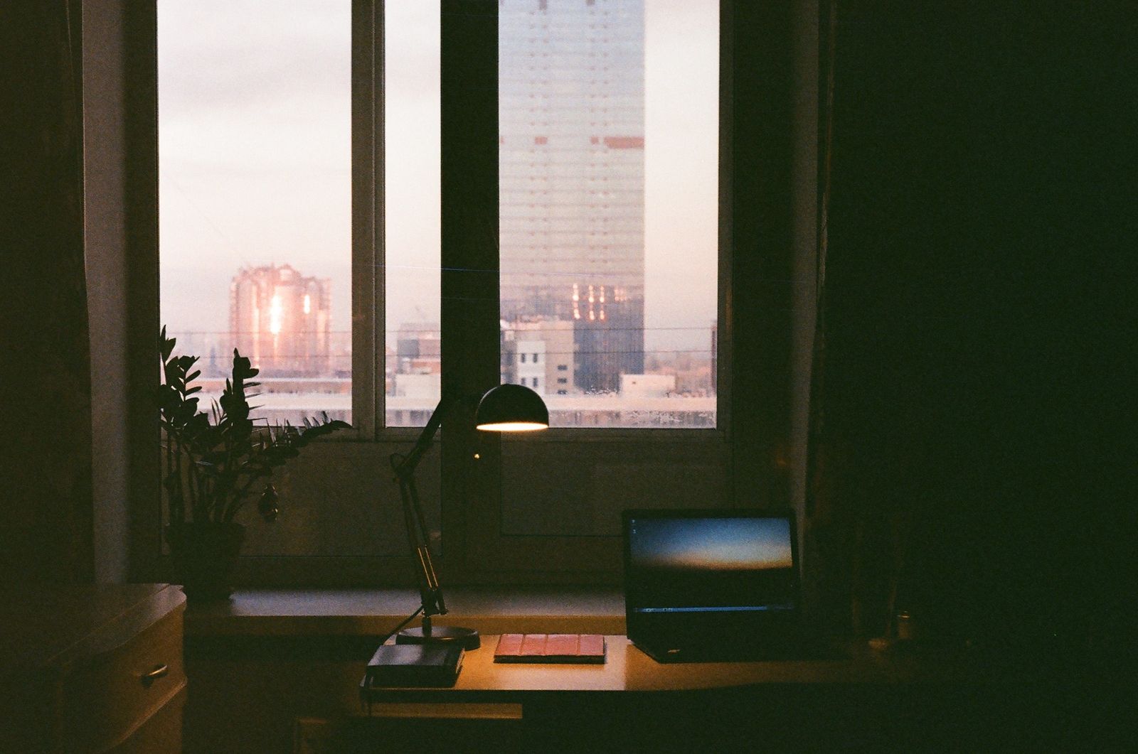 A desk lamp over a workstation at dusk