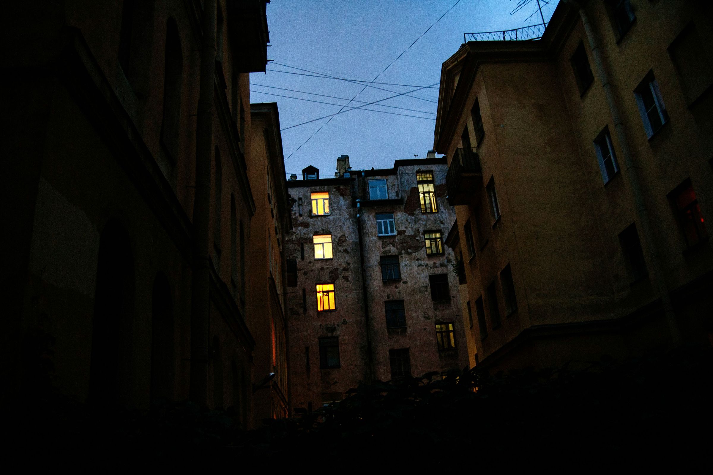 Apartment windows lit at dusk over a quiet courtyard