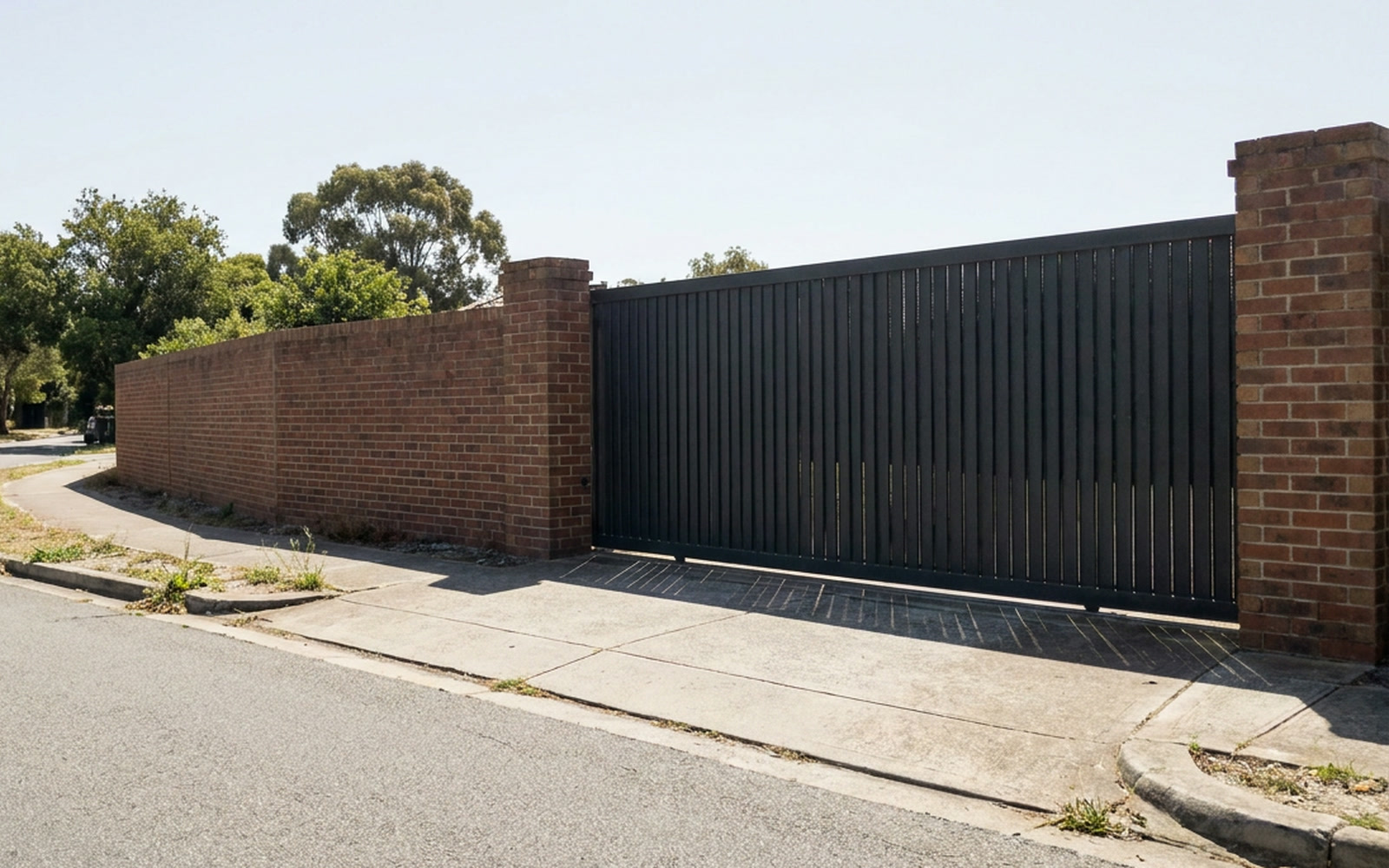 The gated entrance to a residential street, seen from across the road